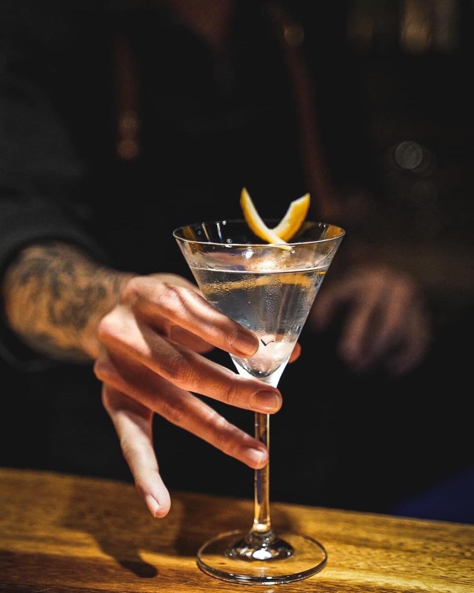 A stemmed glass with a citrus garnish at the counter
